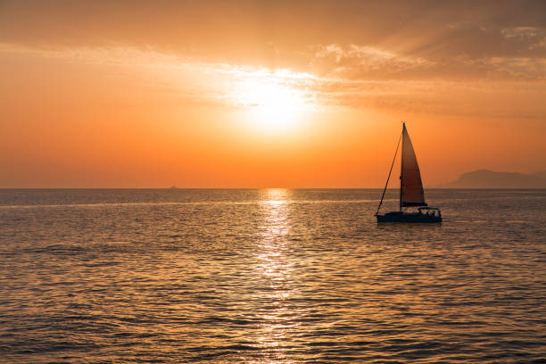 sailboat sailing at sunset